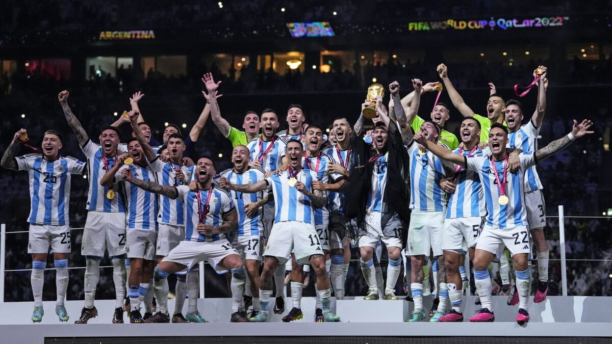 El plantel argentino sobre el podio levanta la copa del Mundial entre la celebración del equipo.